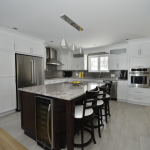 Cuisine moderne avec armoires blanches et grand îlot central sur mesure