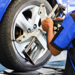 Technicien installant un appareil d’alignement sur la roue d’une voiture.