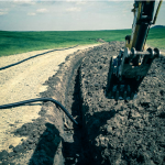 Excavatrice creusant une tranchée pour l’installation d’une conduite