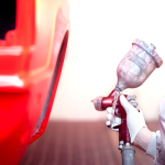 Technicien appliquant de la peinture sur une carrosserie automobile