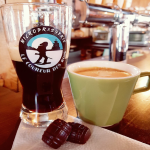 Verre de bière brune à l’effigie de la Microbrasserie Le Coureur des Bois, accompagné d’un café et de deux chocolats.