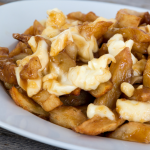 Assiette de poutine composée de frites, de fromage en grains et de sauce brune.