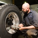 Technicien utilisant une clé à chocs sur la roue d’un camion.