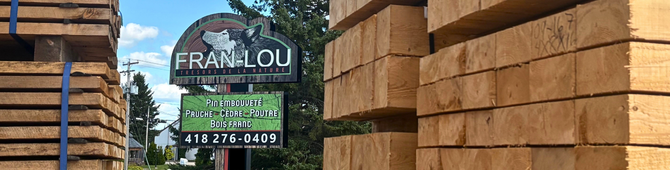 Affiche extérieure de l’entreprise avec poutres de pruche en avant-plan